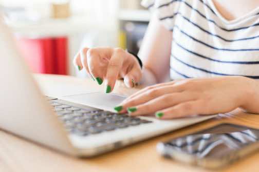 年轻女子在工作场所使用笔记本电脑